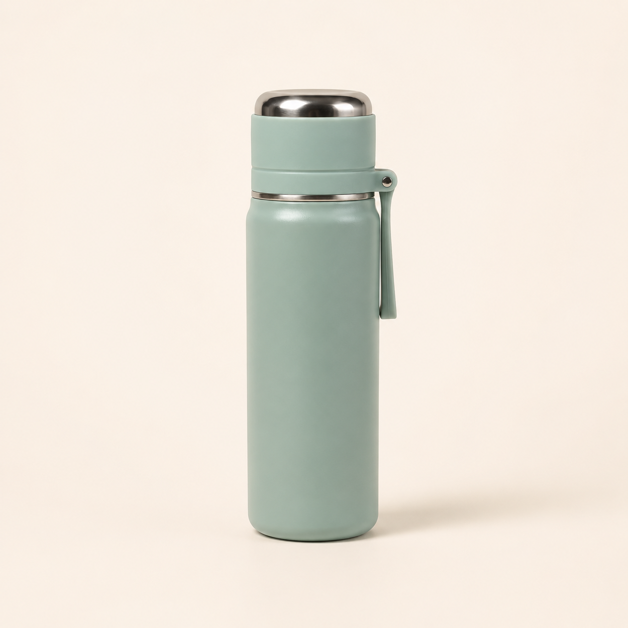 A matte sage green insulated water bottle with a stainless steel lid and carrying loop, standing on a light beige background.