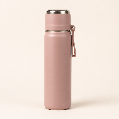 A matte dusty pink insulated water bottle with a stainless steel lid and a matching pink carrying loop, standing upright on a light beige background.