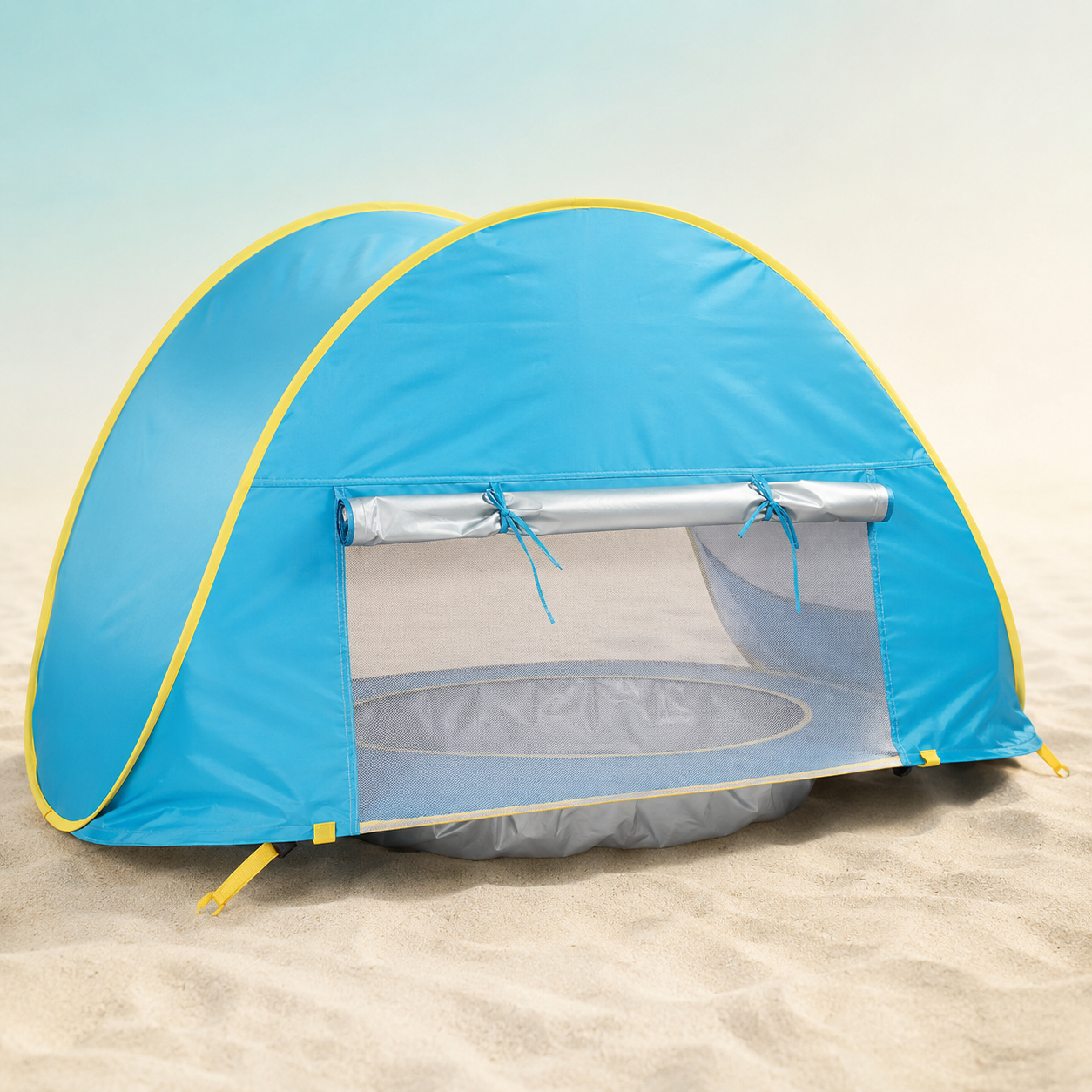 A blue beach pop-up tent with yellow trim and a clear front window, set up on sand with a pale blue sky background.