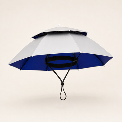 A double-tiered umbrella with a light gray upper canopy and a royal blue lower canopy, suspended by black ribs and a black carrying loop against a solid light beige background.