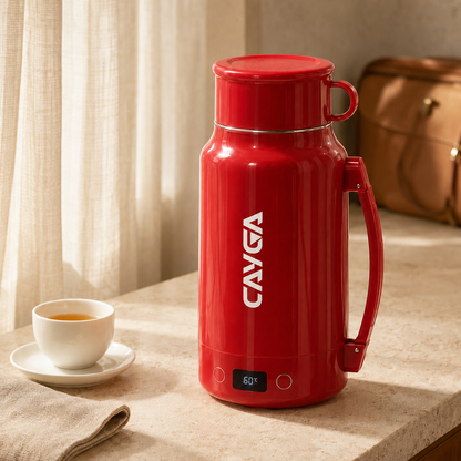 A red CAVGA insulated water bottle with a handle and lid, standing on a countertop beside a cup of tea, with curtains and a brown bag in the background.