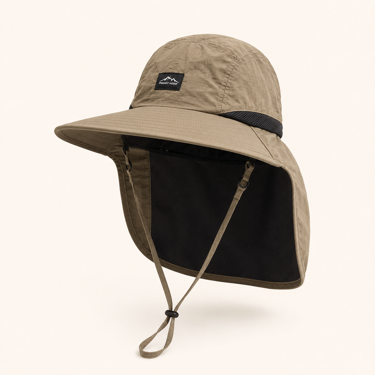 A beige wide-brim sun hat with a built-in neck flap and chin strap, featuring a small black brand patch on the crown, set against a plain off-white background.