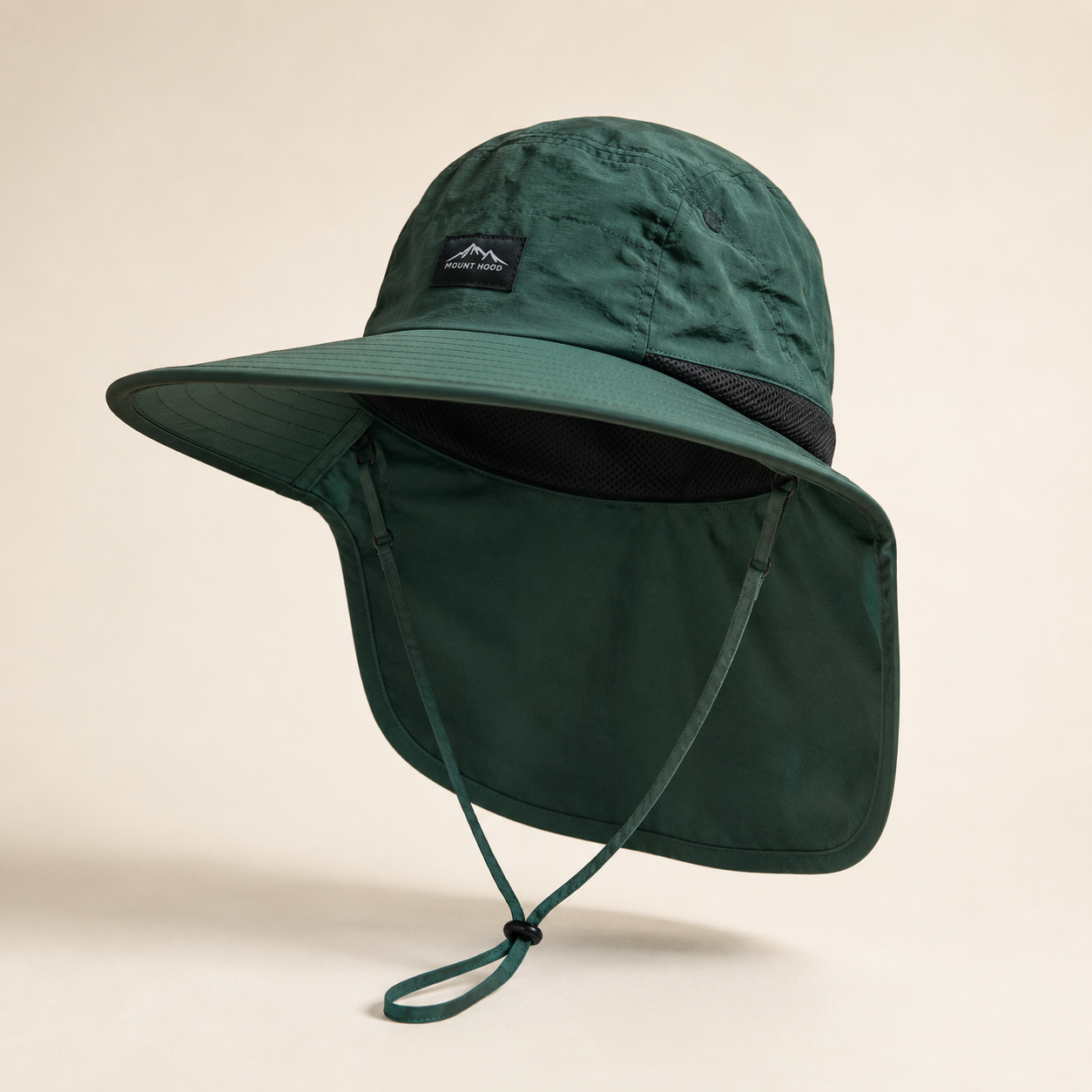 A dark green wide-brim sun hat with an attached neck flap and chin cord, shown on a plain beige background. A small black brand patch is visible on the front crown.