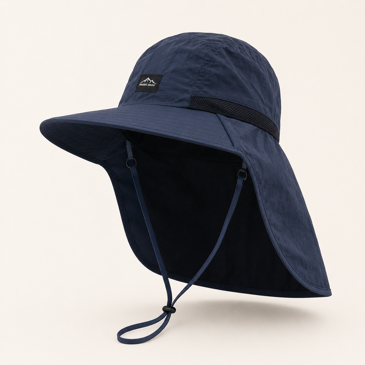 A navy blue wide-brim sun hat with a chin strap and a small black brand patch on the front, shown on a light beige background.